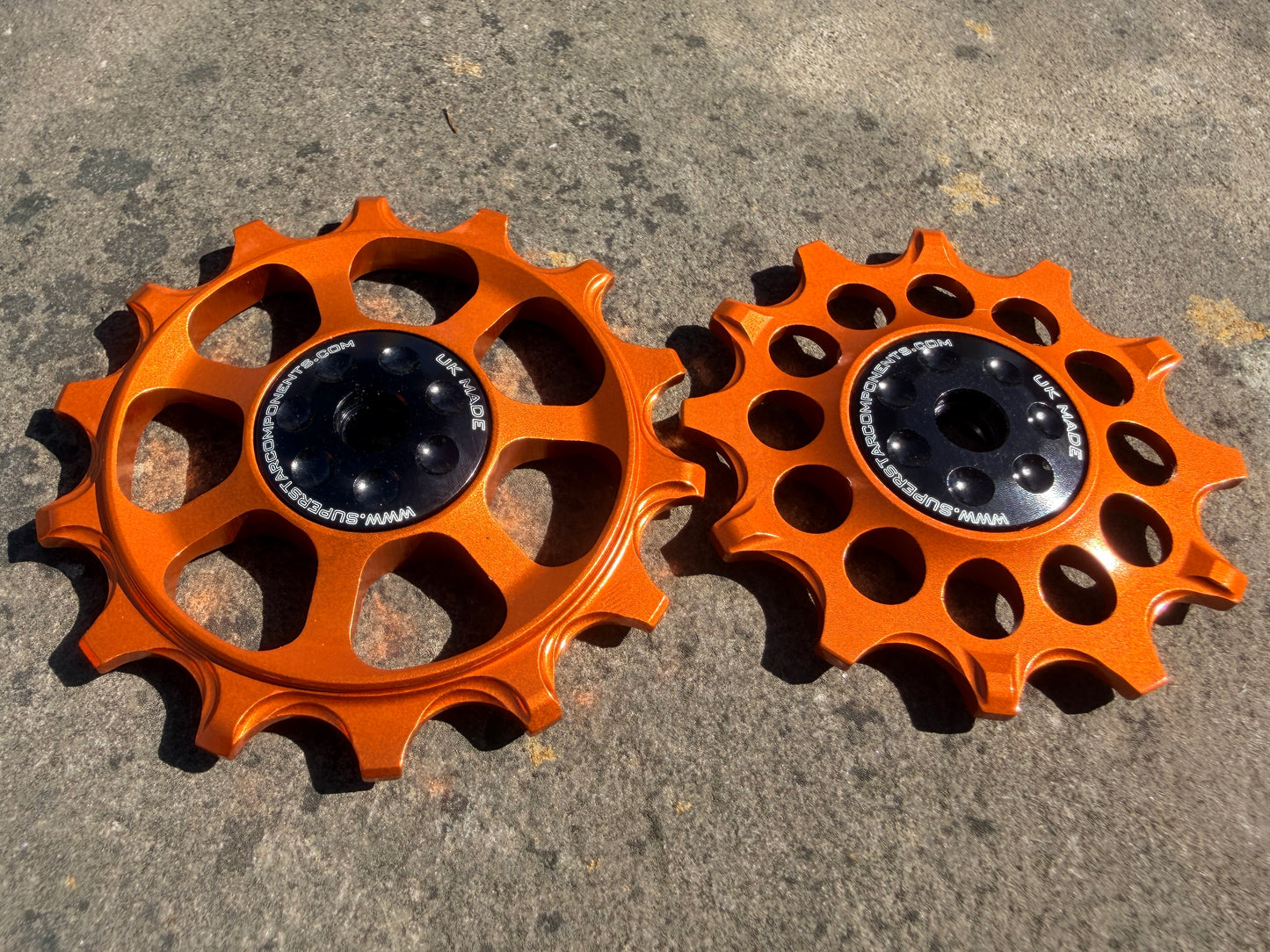 A pair of orange jockey wheels with sealed bearings, designed for use with SRAM EAGLE gx rear derailleurs.