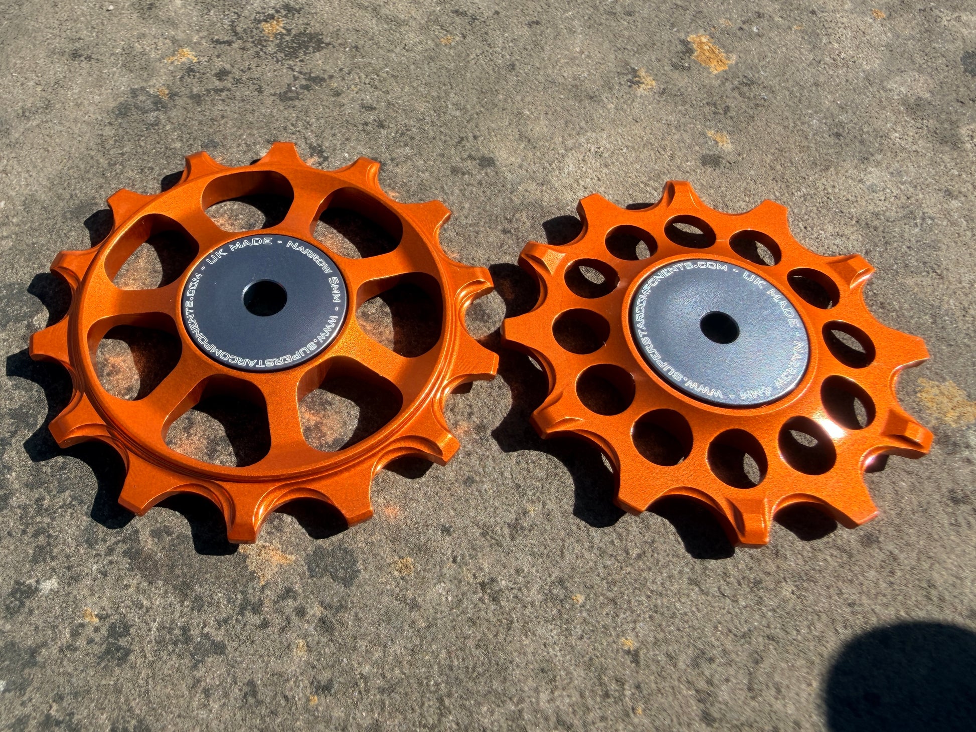 A pair of Orange jockey wheels with sealed bearings, designed for use with SRAM AXS rear derailleurs.