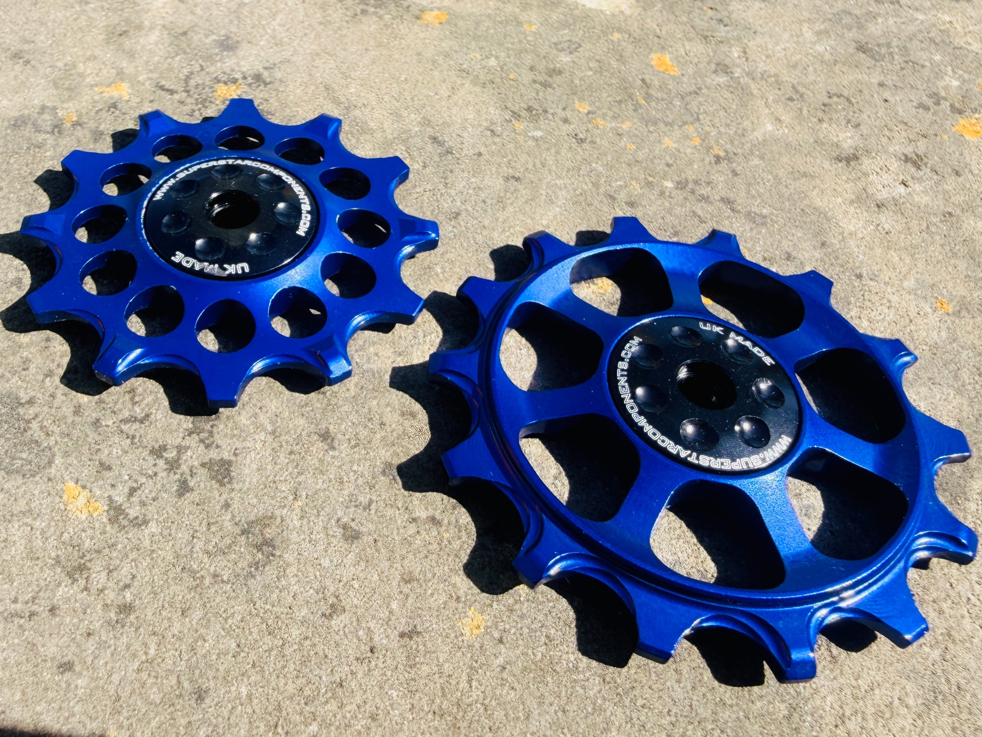 A pair of blue jockey wheels with visible bearing shields, designed for use with SRAM EAGLE rear derailleurs.