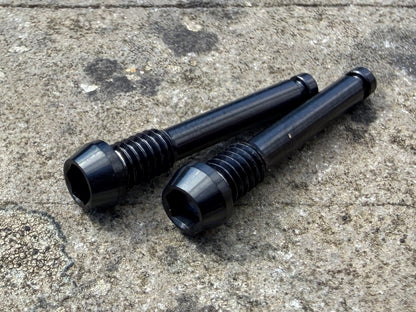black SRAM brake pad retention pins in CNC machined titanium