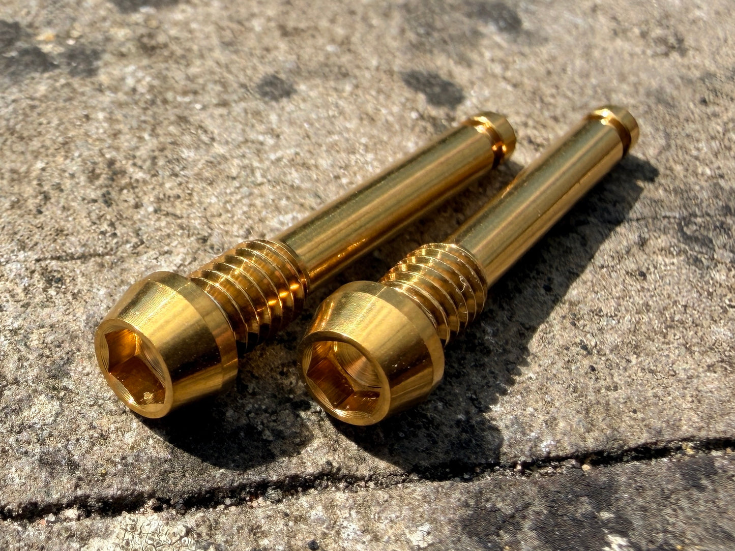 gold SRAM brake pad retention pins in CNC machined titanium